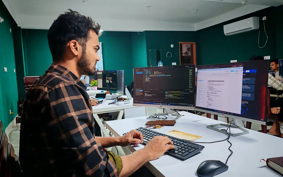 Developer building a web application on two monitors