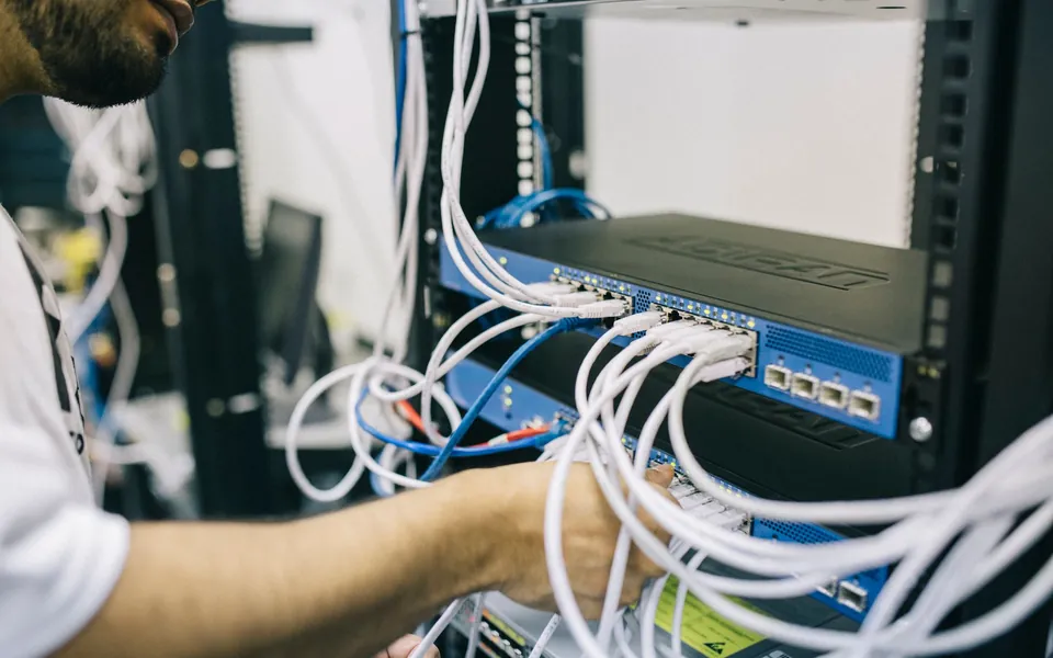 Technician configuring network cabling in a server rack